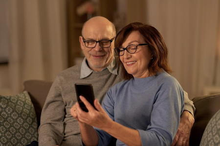 An older couple looking together at her smartphone